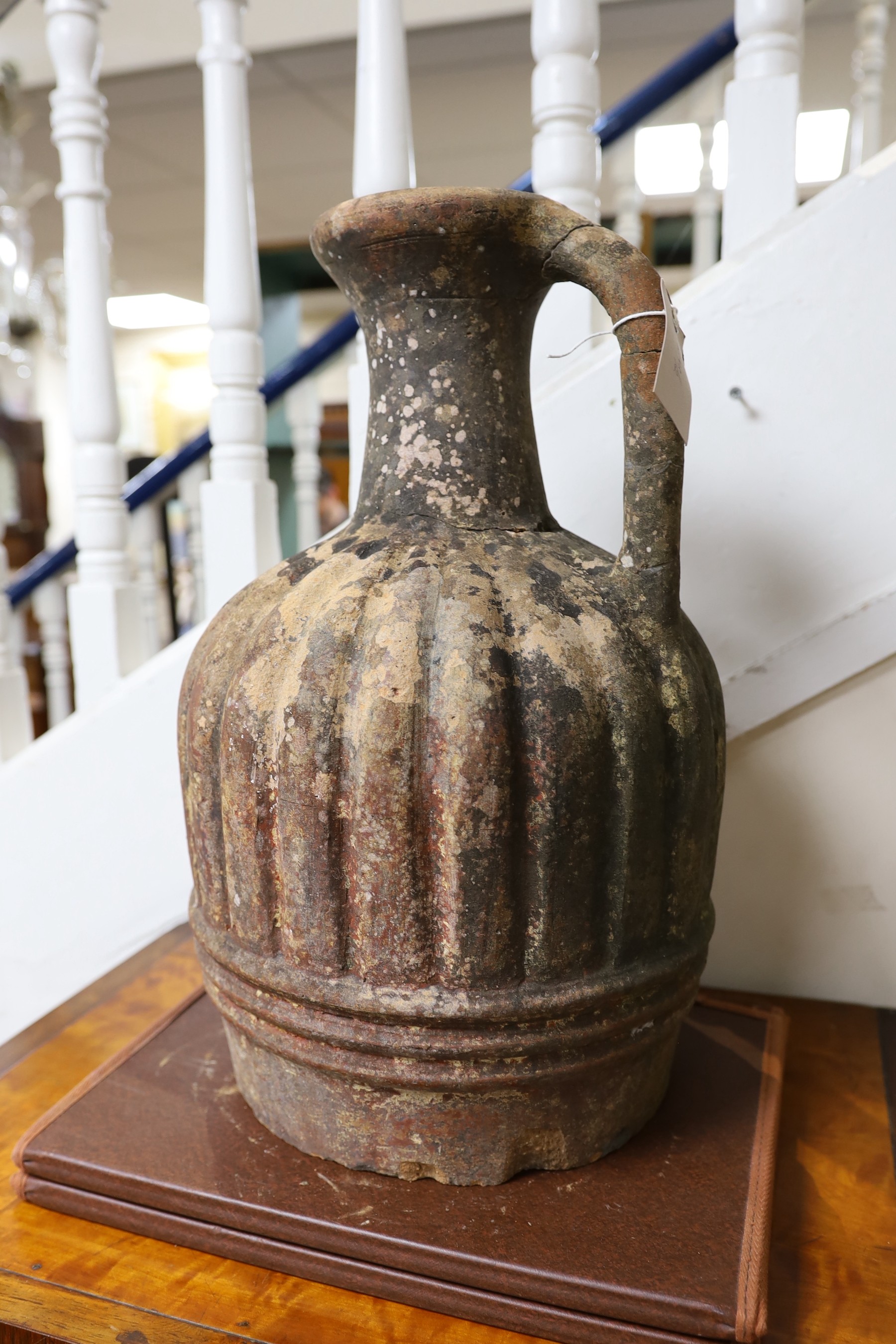 A large Mediterranean terracotta ewer, lacking base, 47cm